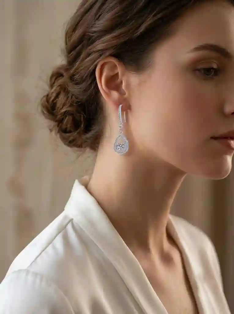 jewelry trends 2026 wholesale Woman wearing teardrop moissanite dangle earrings white silk blouse evening elegance face-framing drop ea MIRAMETAL