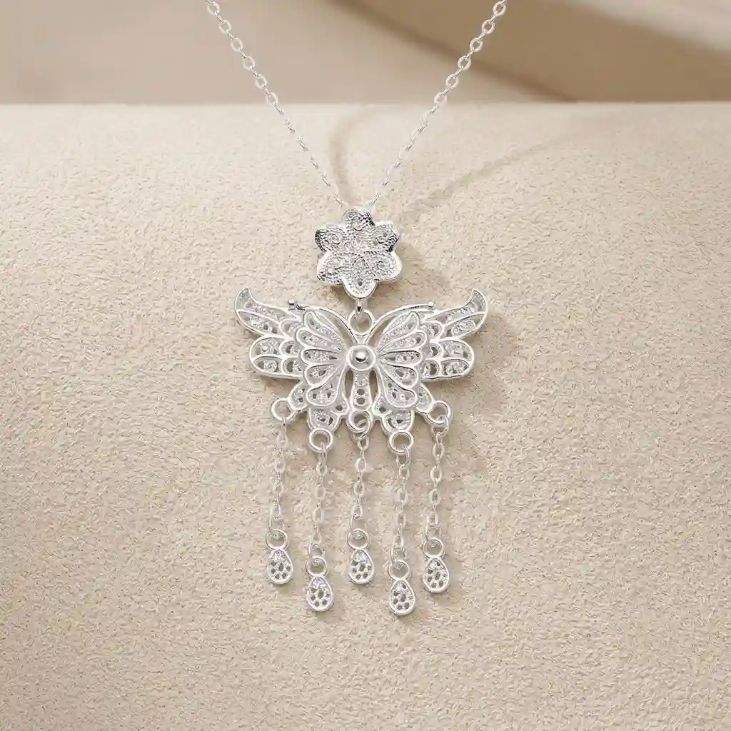 Close-up showing the pure 990 sterling silver quality of the MIRAMETAL butterfly pendant necklace with filigree detail