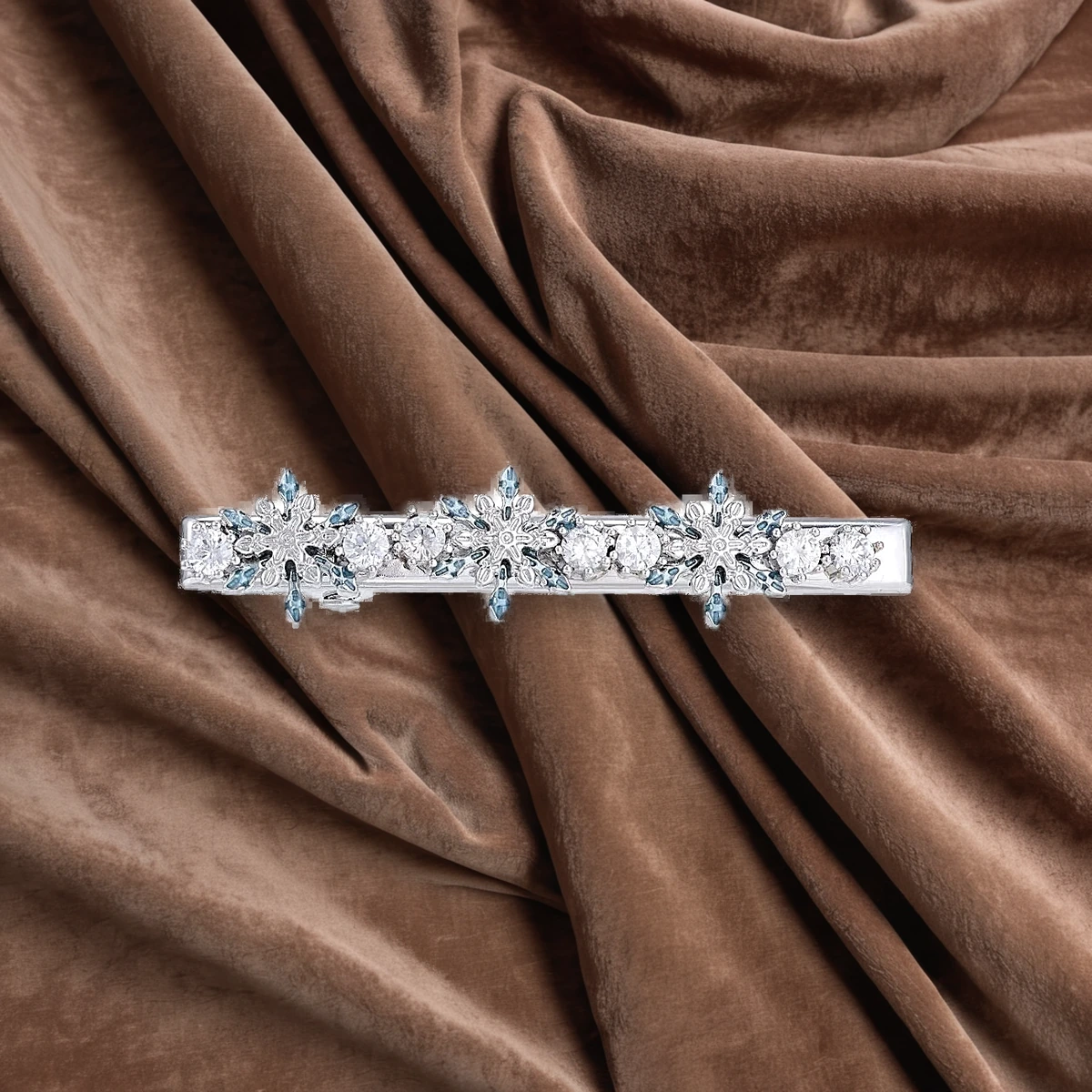 Crystal snowflake hair clip flat lay on taupe velvet