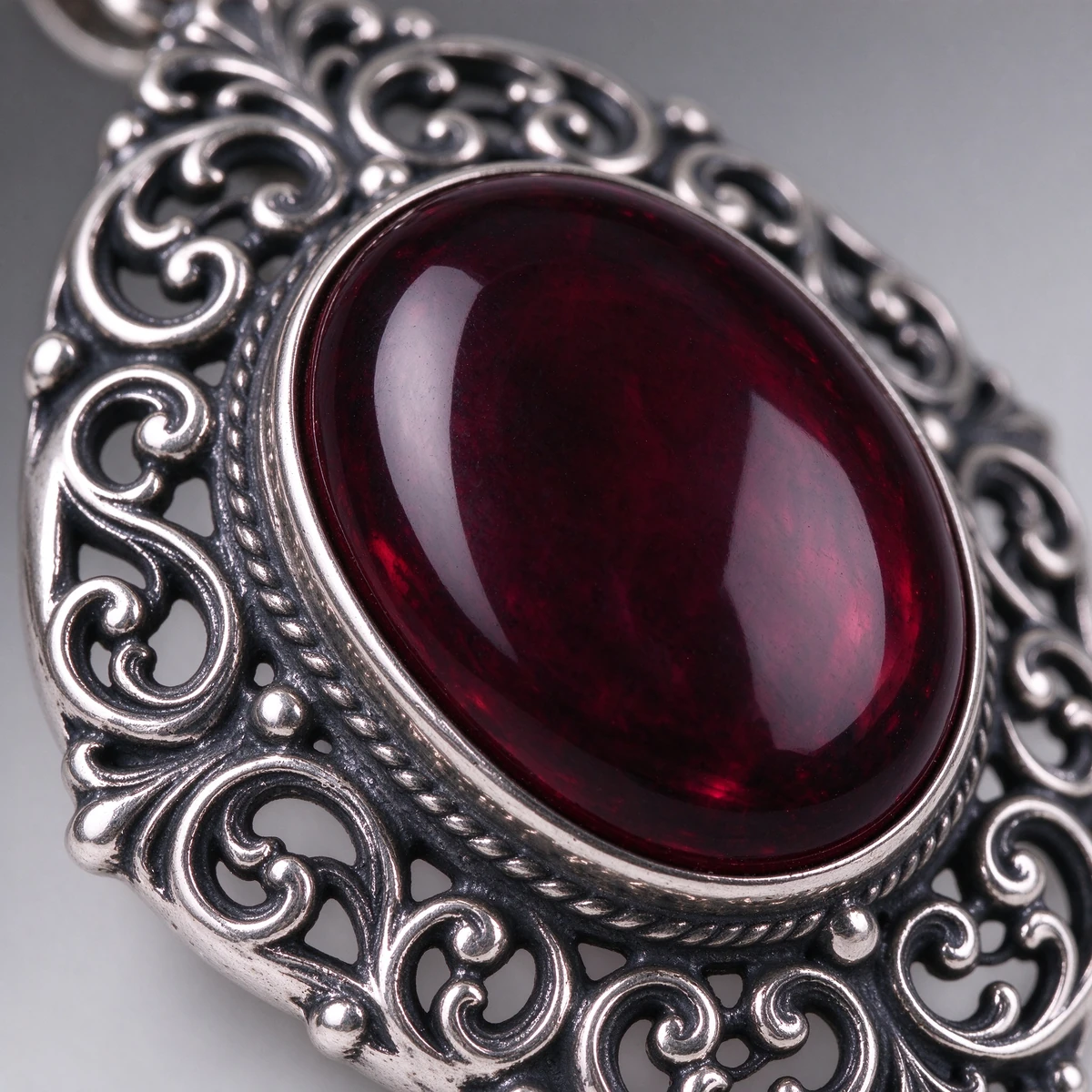Close-up of oval garnet pendant necklace setting in 925 silver