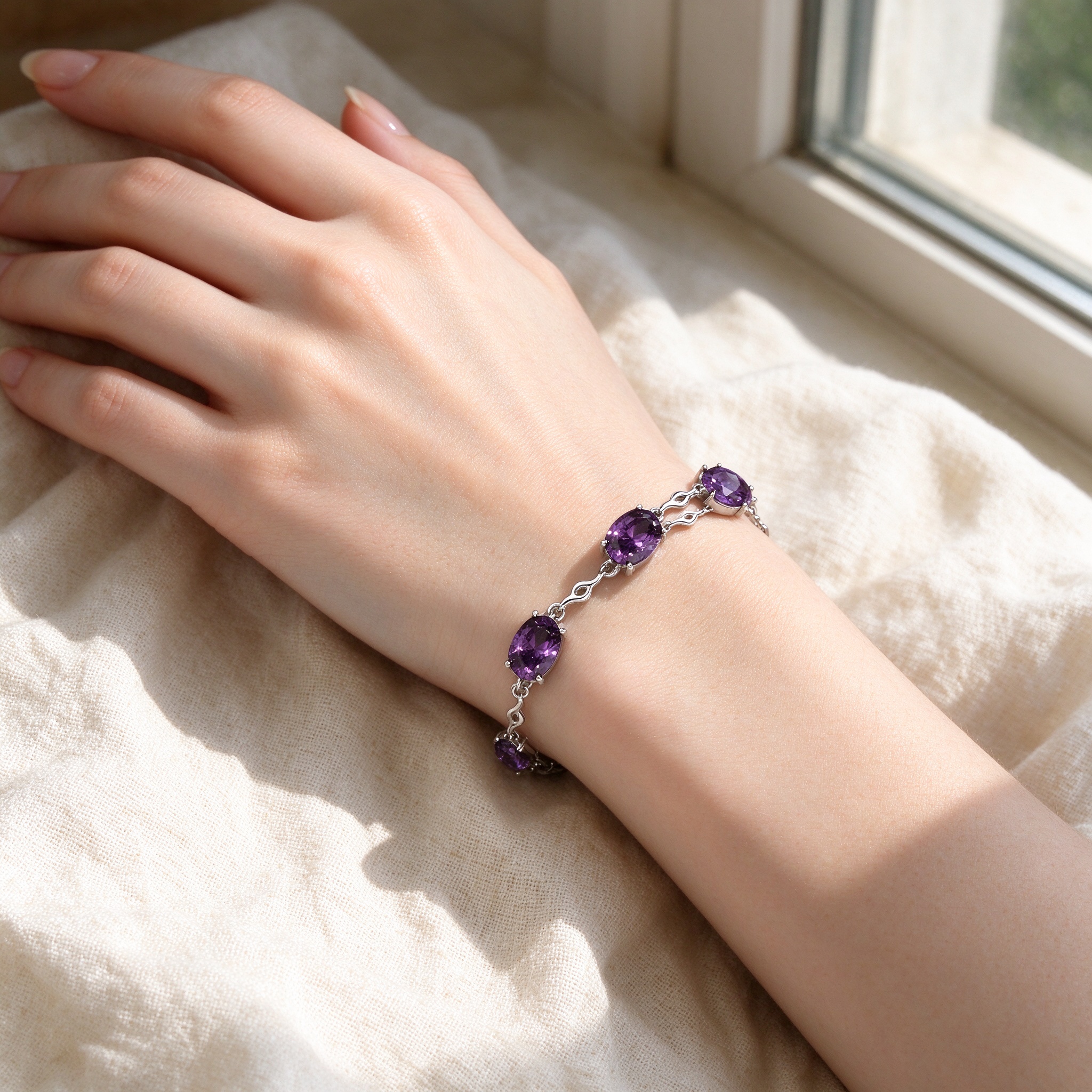 Caucasian woman wearing amethyst oval station bracelet at cafe, cream sweater