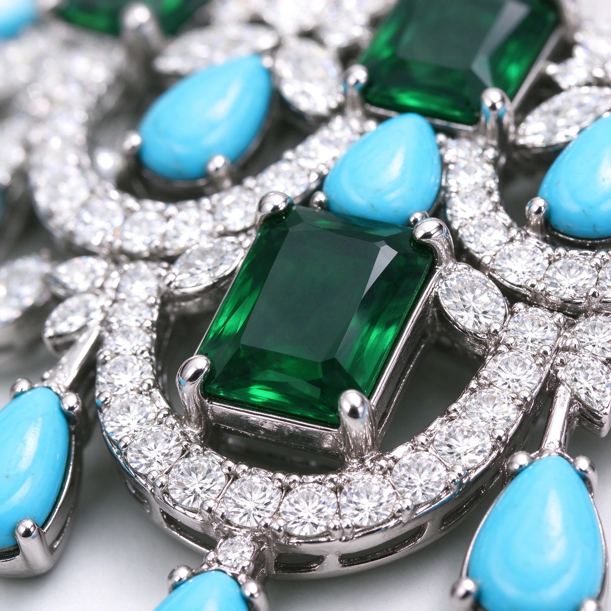 Macro detail of emerald and turquoise zircon stones in bridal color gemstone jewelry set